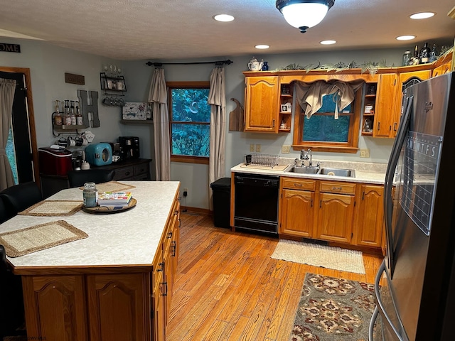 kitchen with open shelves, light countertops, black dishwasher, freestanding refrigerator, and a sink