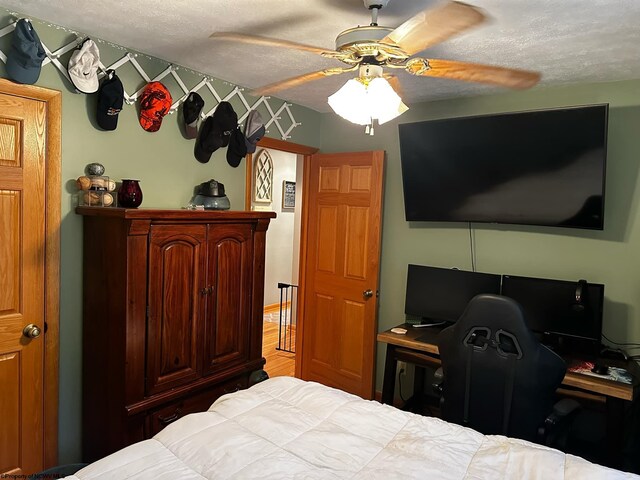 bedroom featuring ceiling fan, a textured ceiling, and hardwood / wood-style flooring