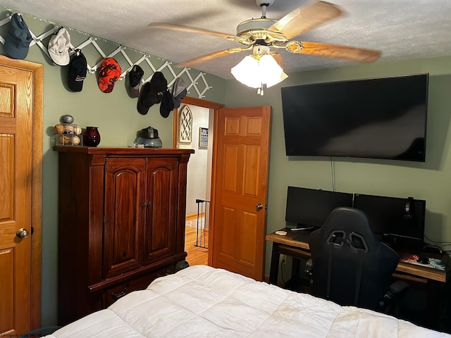 bedroom featuring ceiling fan and a textured ceiling