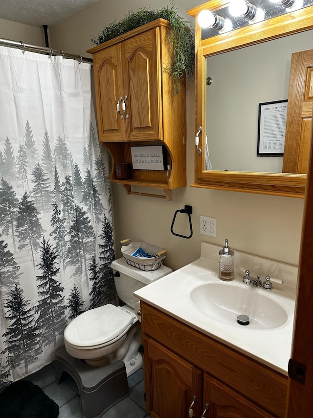 bathroom with a textured ceiling, toilet, vanity, and tile patterned flooring