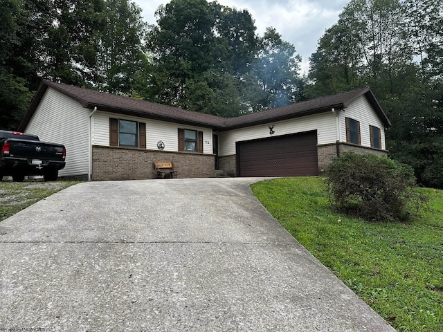 ranch-style home featuring brick siding, a front lawn, concrete driveway, and a garage