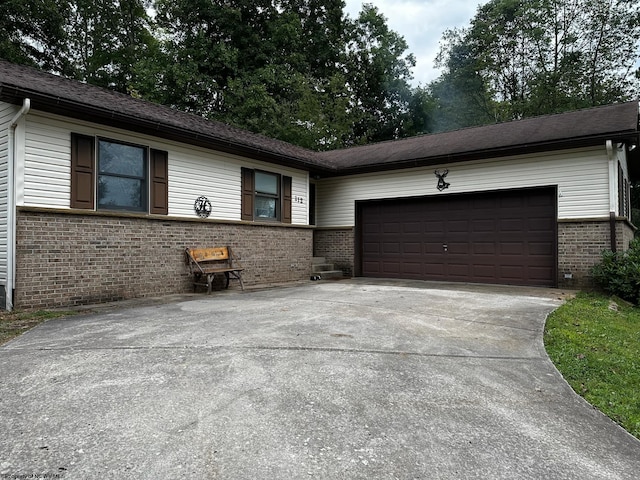 ranch-style house featuring brick siding, driveway, and a garage