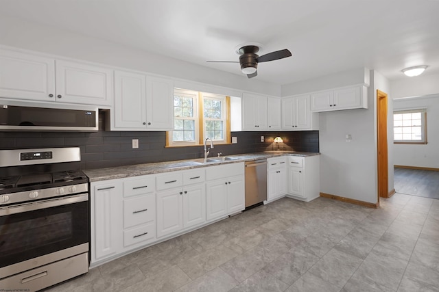 kitchen with stainless steel appliances, a sink, a wealth of natural light, and white cabinets