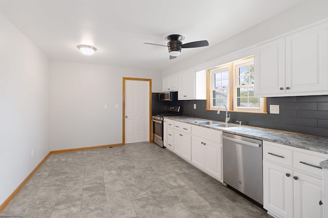 kitchen featuring tasteful backsplash, baseboards, white cabinets, stainless steel appliances, and a sink