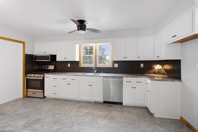 kitchen featuring tasteful backsplash, appliances with stainless steel finishes, white cabinets, and a sink