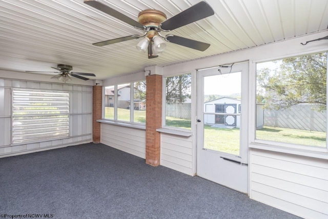 unfurnished sunroom featuring ceiling fan