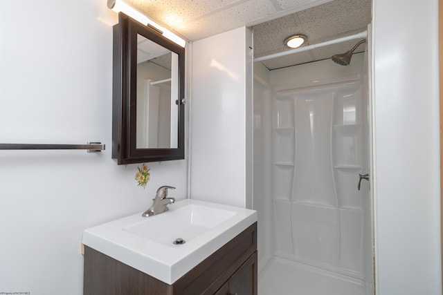 full bath with a shower, a paneled ceiling, and vanity