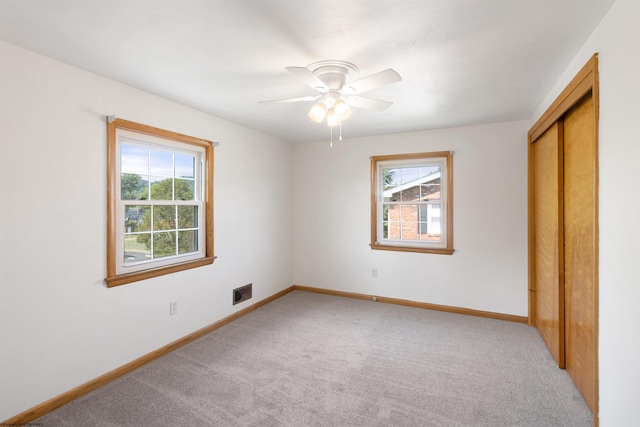 unfurnished bedroom with a closet, carpet flooring, visible vents, and baseboards