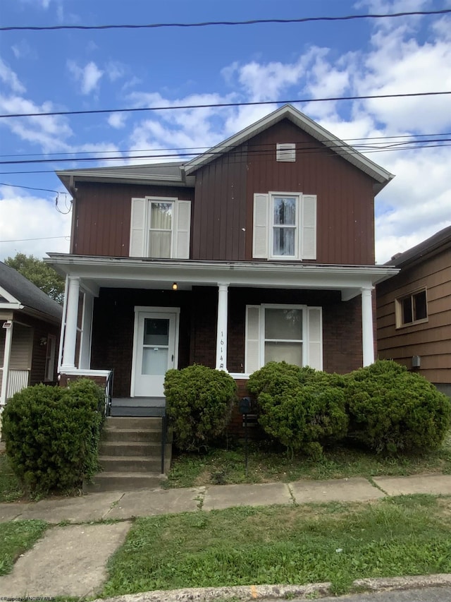 traditional-style house featuring a porch and brick siding