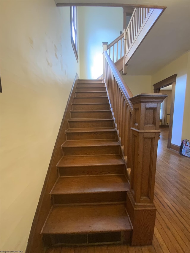 stairway with hardwood / wood-style flooring and baseboards