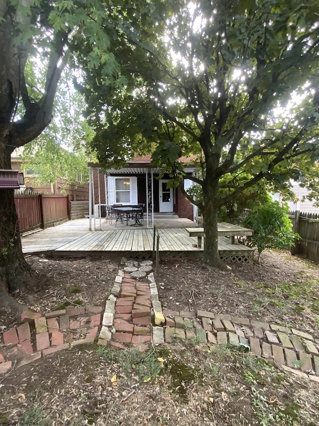 back of property with fence and a wooden deck