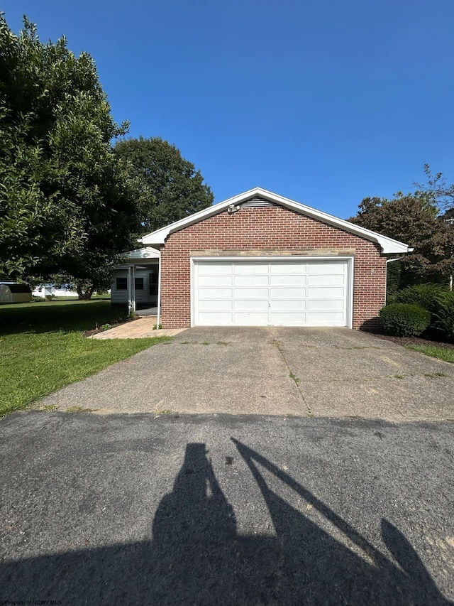 view of front facade with driveway, brick siding, and an attached garage