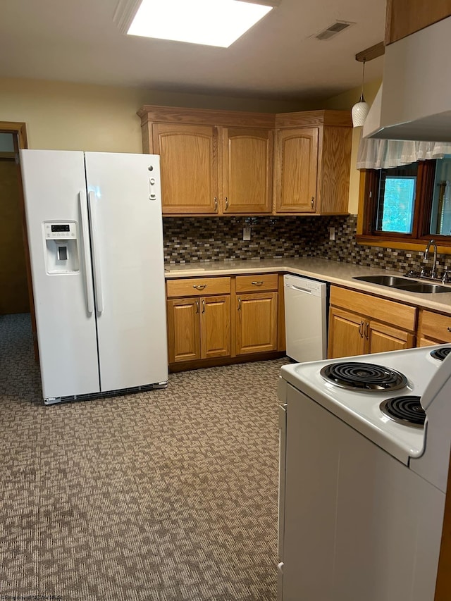 kitchen featuring hanging light fixtures, white appliances, a sink, and light countertops