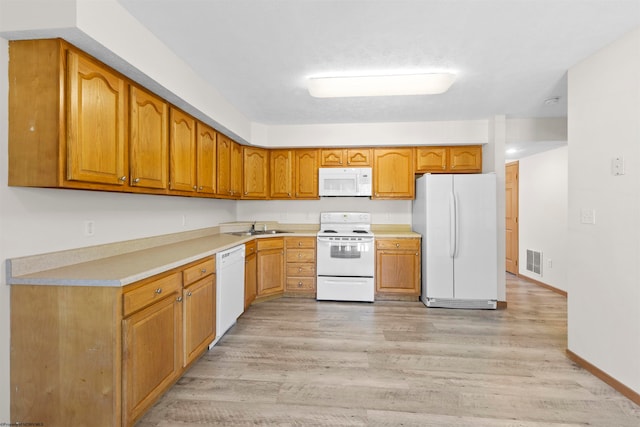 kitchen featuring sink, white appliances, and light wood-type flooring