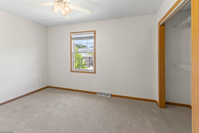 carpeted empty room featuring ceiling fan