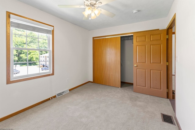 unfurnished bedroom featuring a closet, ceiling fan, and light carpet