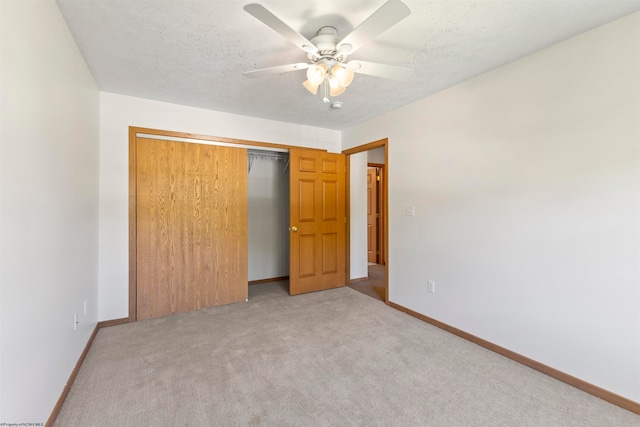 unfurnished bedroom with a textured ceiling, carpet flooring, ceiling fan, and a closet