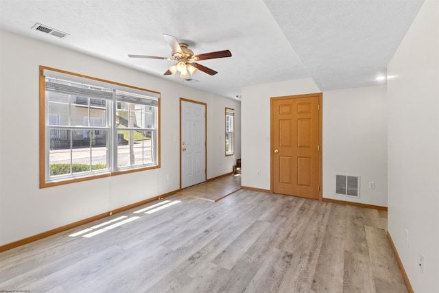 entryway featuring ceiling fan, light hardwood / wood-style floors, and a textured ceiling