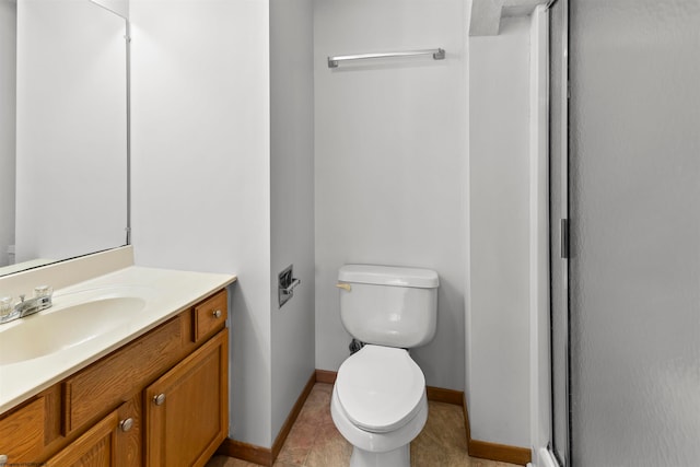 bathroom with tile patterned flooring, toilet, vanity, and walk in shower