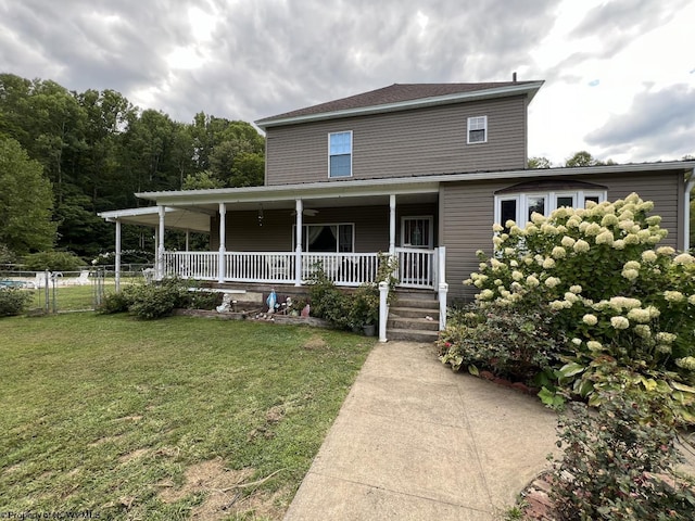 farmhouse featuring a porch, a front yard, and fence