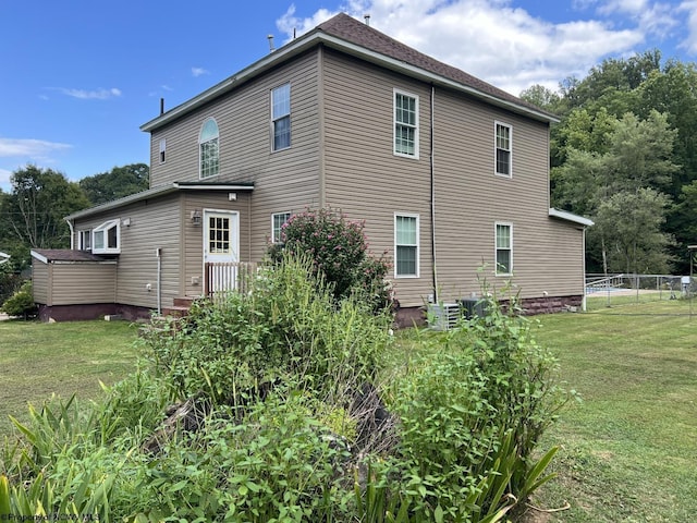 rear view of property featuring fence and a yard