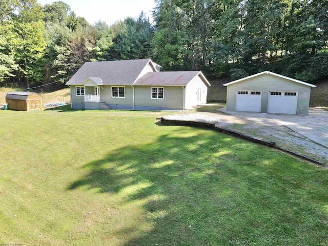 view of front of property with a garage, a front yard, and a storage shed