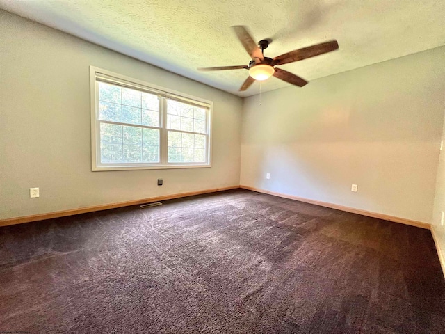 carpeted spare room featuring a textured ceiling and ceiling fan