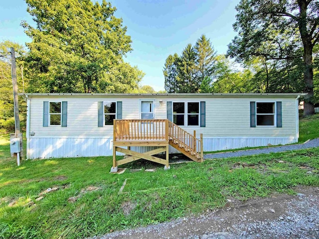 manufactured / mobile home featuring a deck and a front yard