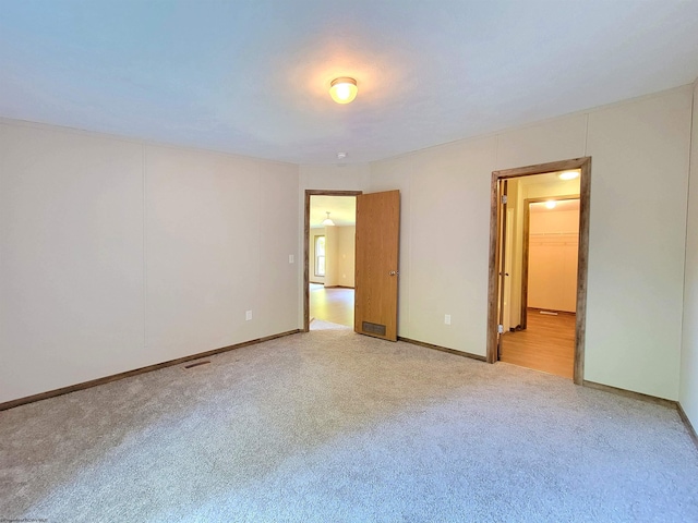 unfurnished bedroom with light colored carpet and visible vents