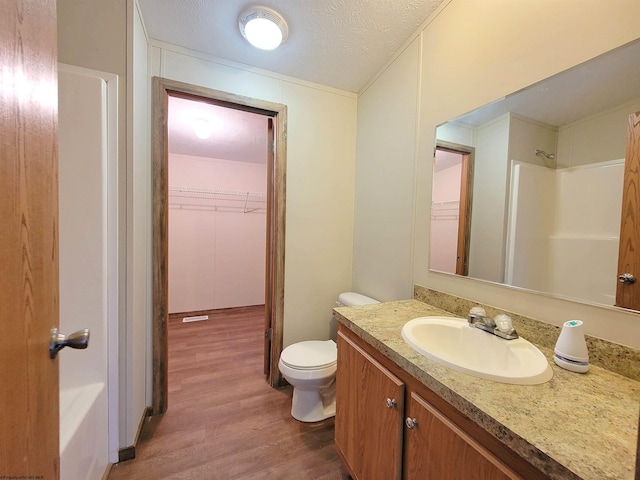 bathroom featuring hardwood / wood-style floors, toilet, a textured ceiling, and vanity