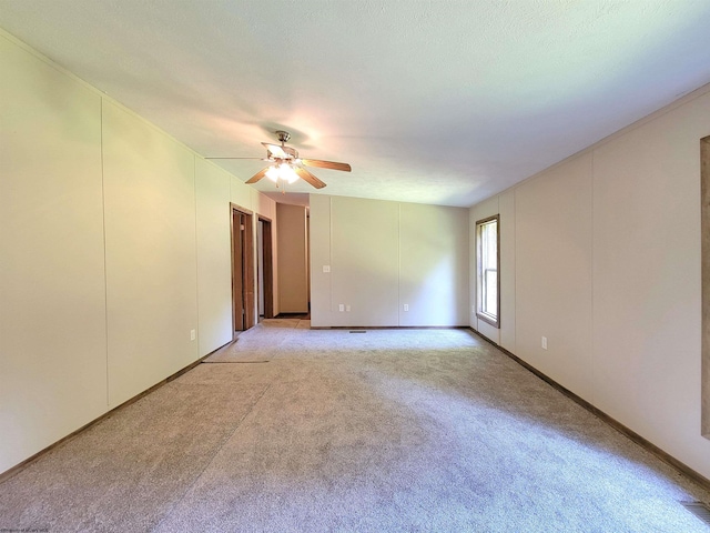 carpeted spare room featuring ceiling fan