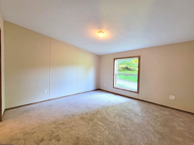 empty room featuring carpet floors and baseboards