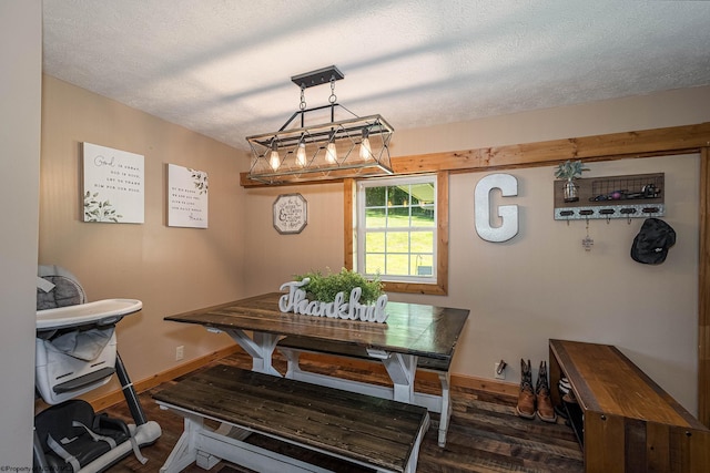 dining space with dark wood-type flooring and a textured ceiling