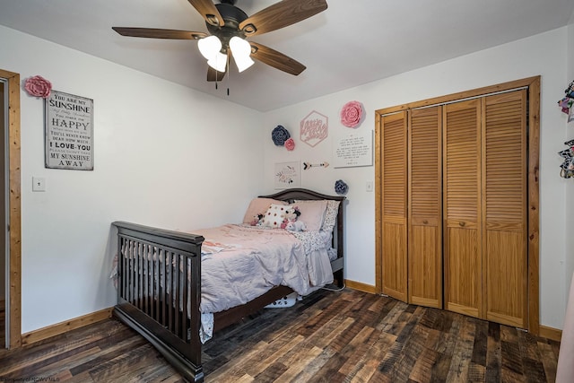 bedroom with a closet, dark wood finished floors, a ceiling fan, and baseboards