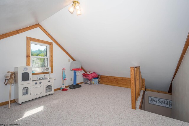 recreation room featuring vaulted ceiling and carpet