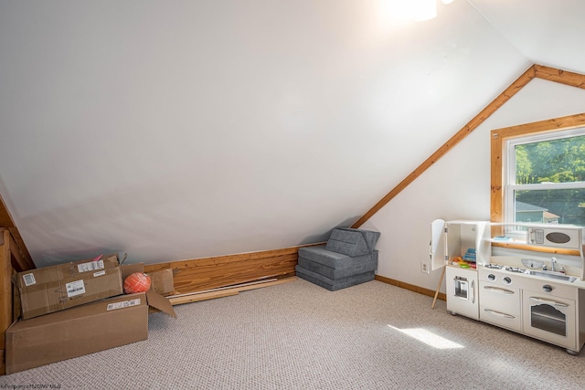 recreation room with lofted ceiling, light carpet, and baseboards