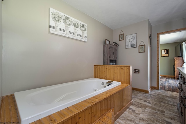 bathroom with baseboards and a bath