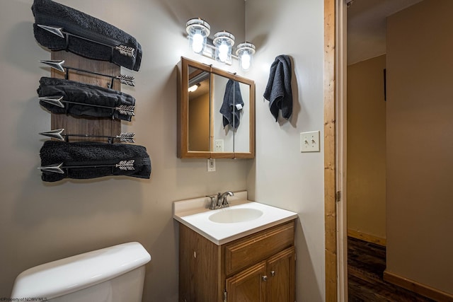 bathroom featuring toilet, hardwood / wood-style flooring, and vanity