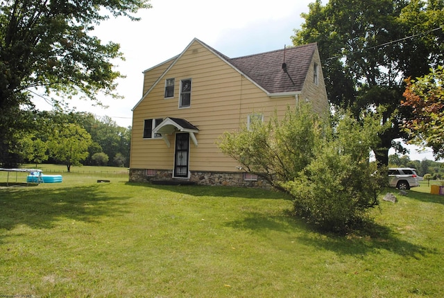 view of front of home featuring a shingled roof and a front lawn