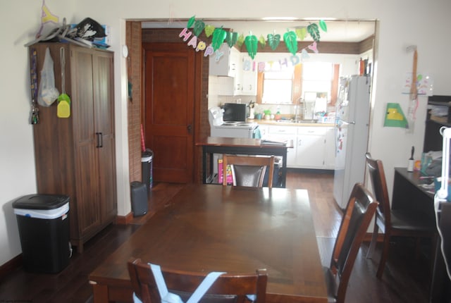 kitchen with dark wood-type flooring, white appliances, white cabinetry, and a sink