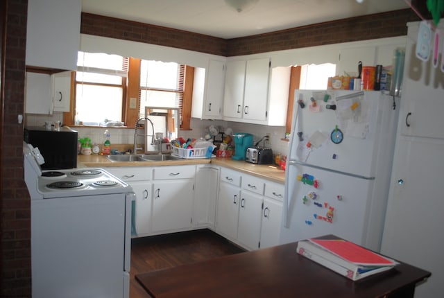 kitchen featuring white appliances, a sink, white cabinetry, and decorative backsplash