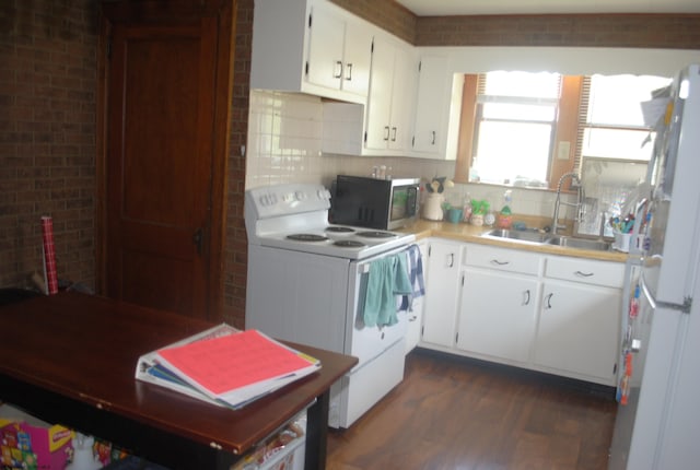 kitchen featuring dark wood-style floors, light countertops, backsplash, a sink, and white appliances