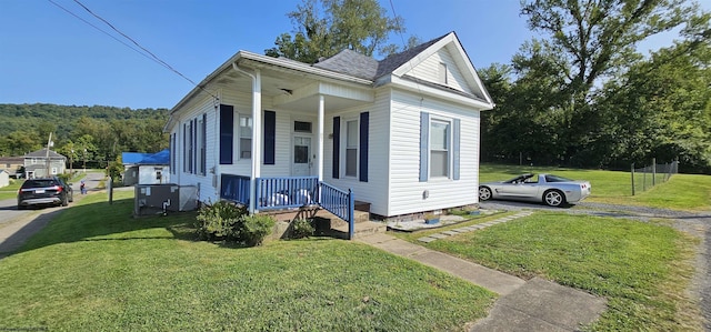 bungalow-style house featuring a porch, a front yard, and fence