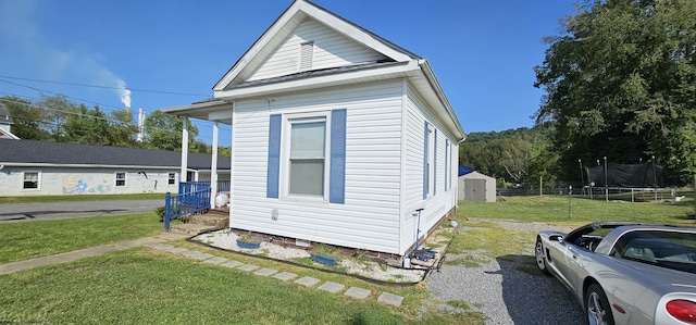 view of side of home with an outbuilding, a trampoline, a storage shed, and a lawn