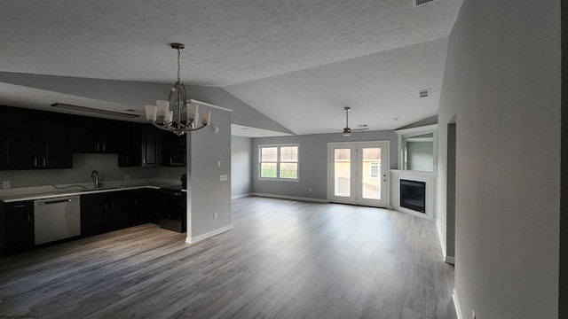 kitchen featuring dishwasher, lofted ceiling, sink, and light hardwood / wood-style floors