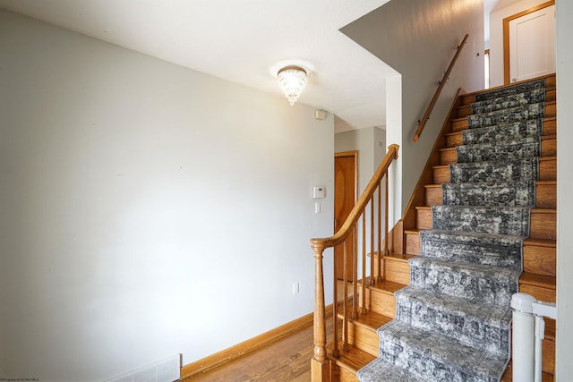 staircase with hardwood / wood-style floors