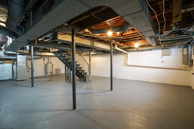 basement with gas water heater, electric panel, and heating unit