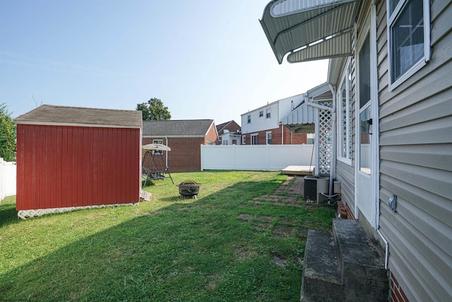 view of yard featuring a storage shed, a fire pit, and central air condition unit