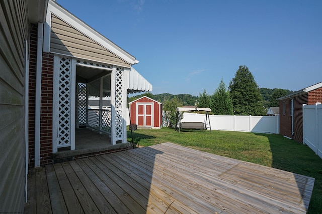 wooden terrace with a storage unit and a yard