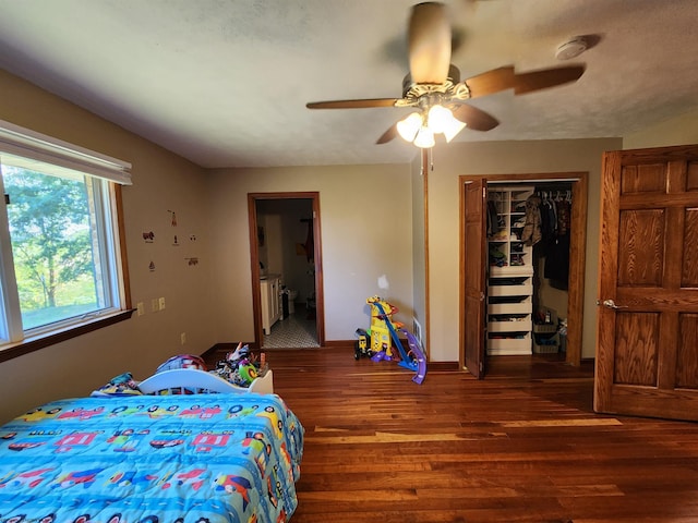 bedroom featuring ceiling fan, a closet, and dark wood-type flooring